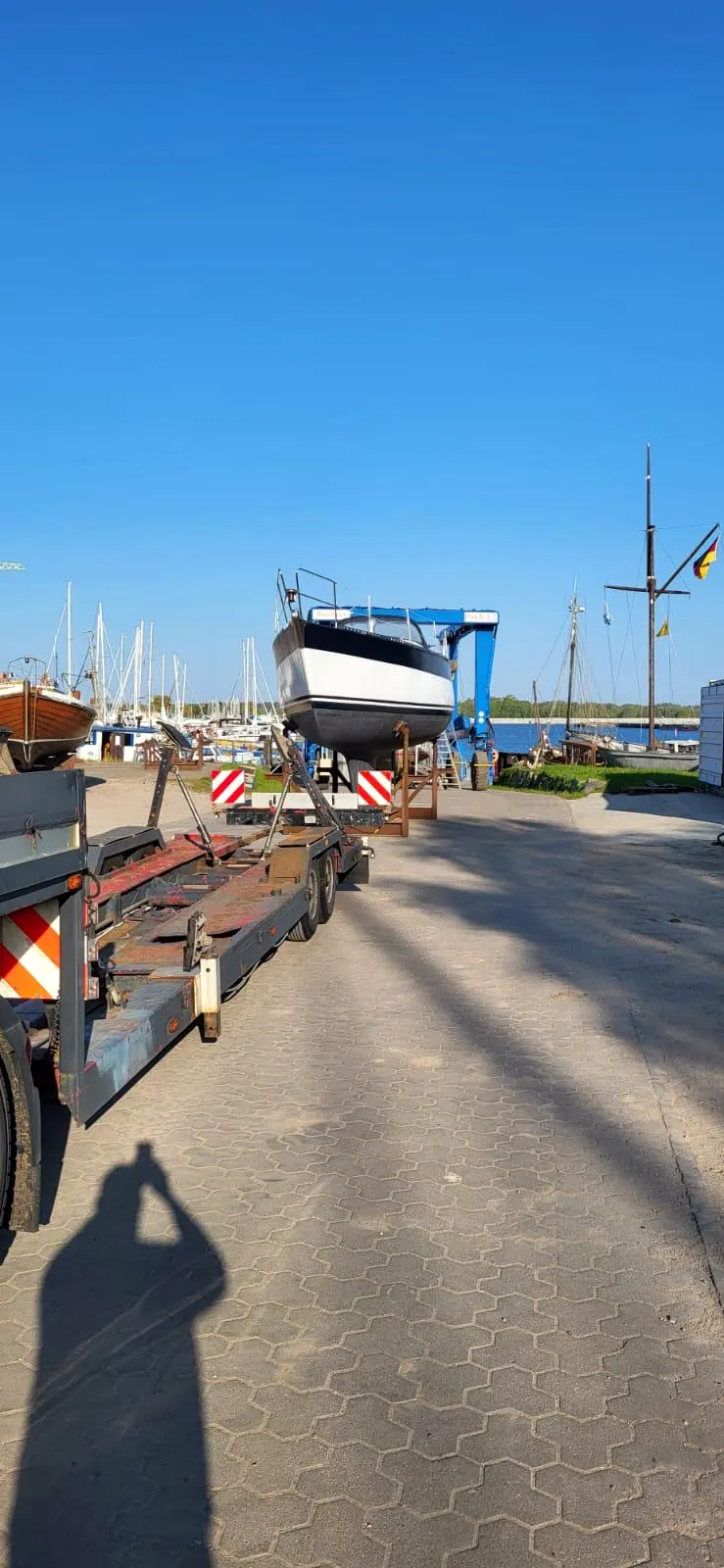 Segelyacht im Travellift über dem Bootsauflieger